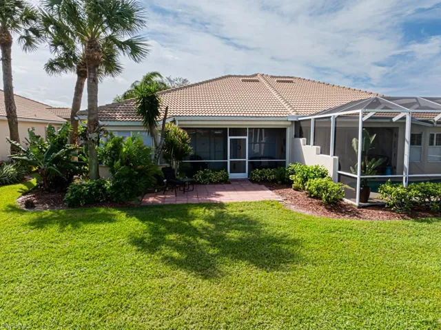 Rear view of property featuring a patio area, a yard, and glass enclosure