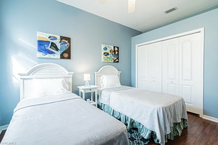 Bedroom with dark wood-type flooring, a closet, and ceiling fan