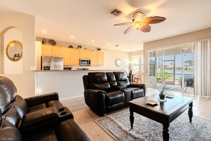 Living room featuring light tile patterned floors and ceiling fan