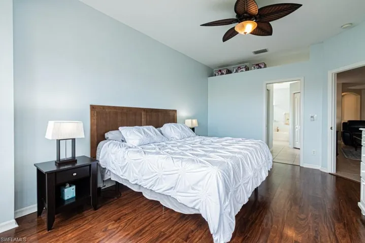 Bedroom featuring connected bathroom, ceiling fan, and dark wood-type flooring