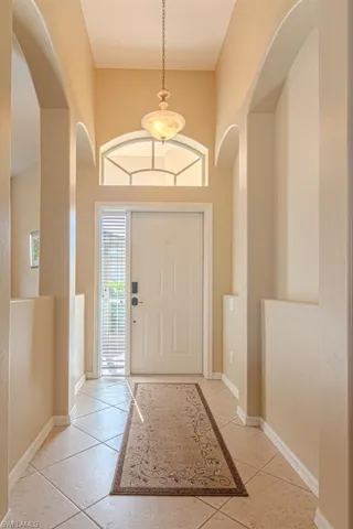 Entrance foyer with light tile patterned flooring and a towering ceiling
