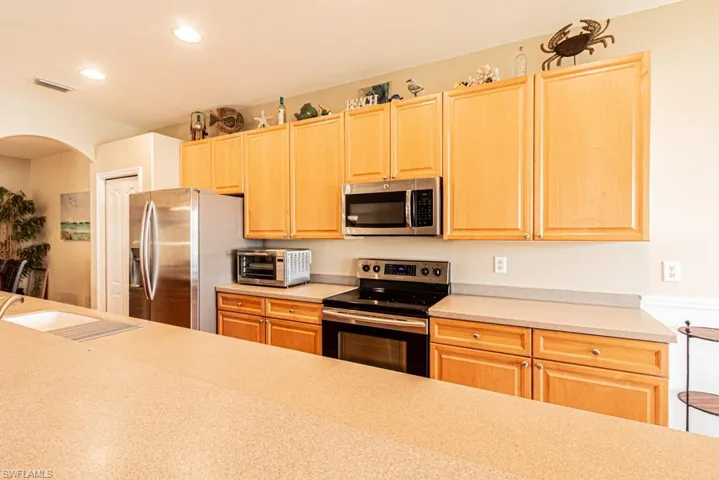 Kitchen featuring stainless steel appliances, sink, and light brown cabinetry