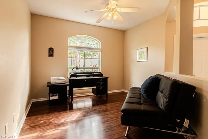 Office area with dark hardwood / wood-style floors and ceiling fan