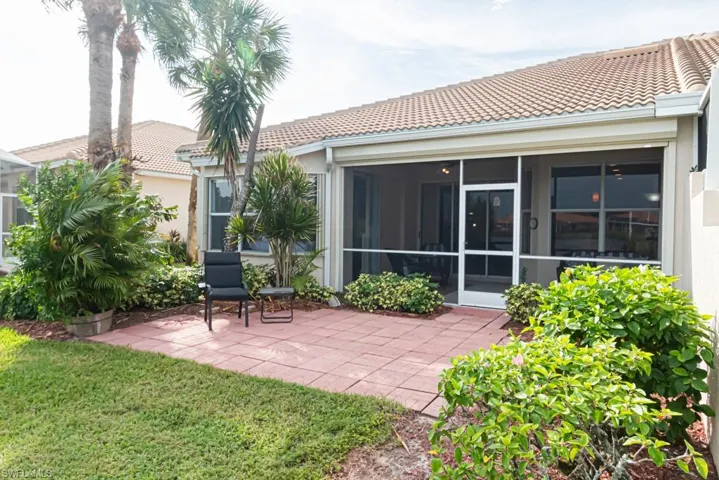 Rear view of property featuring a patio area, a lawn, and a sunroom