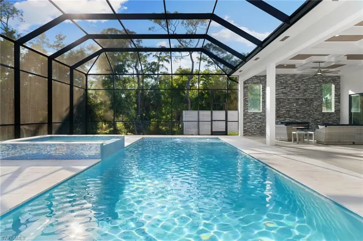 Private outdoor oasis with an expansive entertainment deck, resort-style pool with tanning shelf and bubbler features, spa