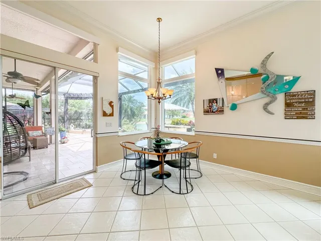 Dining area with a sunroom, crown molding, and light tile patterned floors