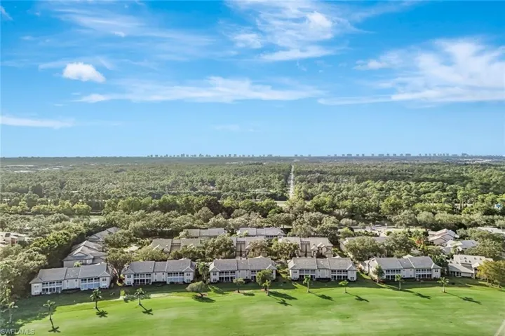 Aerial view of residential area with a heavily wooded area and a golf course