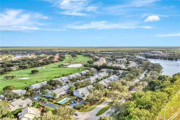 View of property location featuring a local golf course, a large body of water, and nearby suburban area