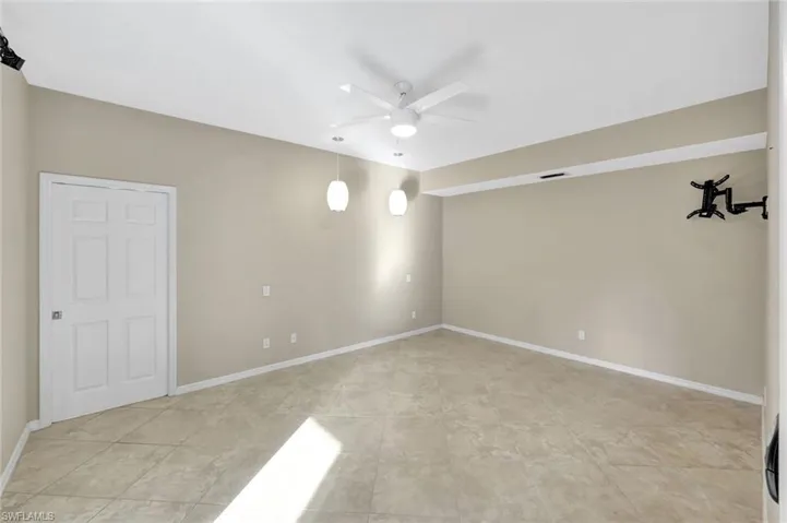 Unfurnished room with ceiling fan and baseboards