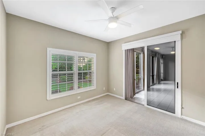 Carpeted empty room featuring a ceiling fan and baseboards