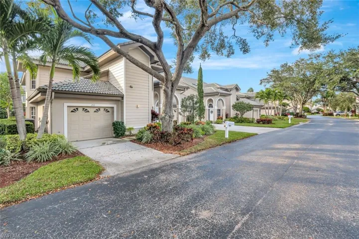 View of front facade with an attached garage, a residential view, driveway, and a tiled roof
