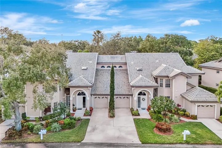 View of front of property featuring concrete driveway, a garage, a tile roof, and stucco siding