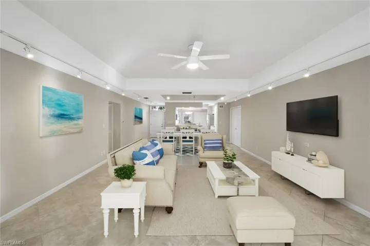virtually staged Living area featuring rail lighting and ceiling fan