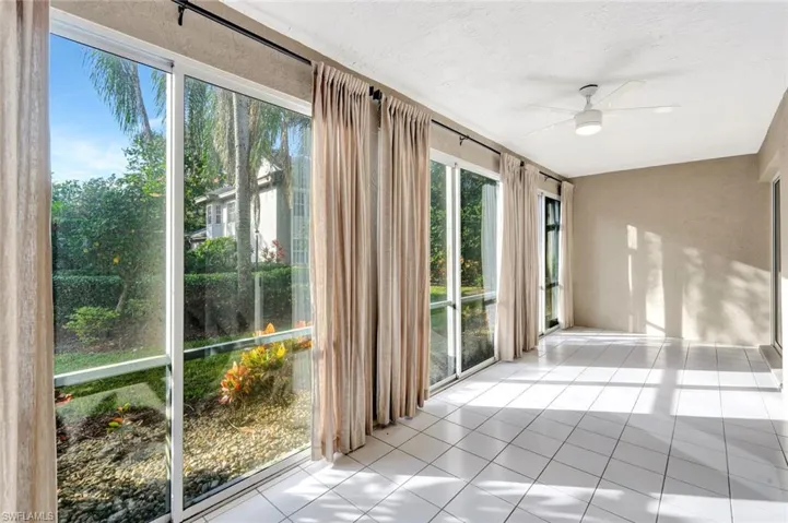 Screen & glass Lanai featuring ceiling fan and tile patterned flooring
