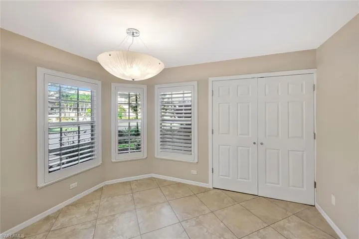 Unfurnished dining area featuring light tile patterned flooring and baseboards