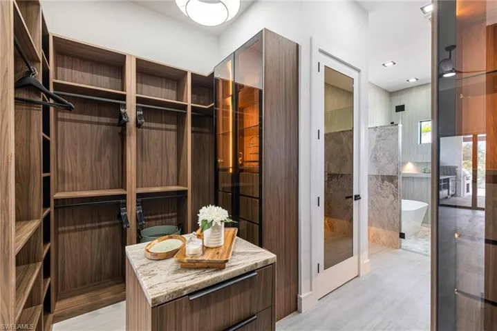 This Primary custom closet with LED lighting the the Glass doors with room for so much belongs in a MILLION Dollar home.... Oh and an Island with drawers and shelving for shoes..... You just don't see this in a home under a Million dollars! You MUST See this one!