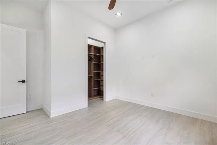 Guest bedroom 1 with Custom shelving and Light Filtering Custom window shades.