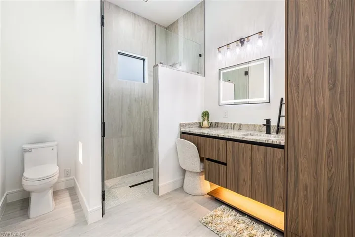 WOW! A guest bathroom with a vanity area, floating vanity with a LARGE Linen closet lighted fog free mirror, lots of light and a bench in the shower with LED Niches? This bathroom has it all!