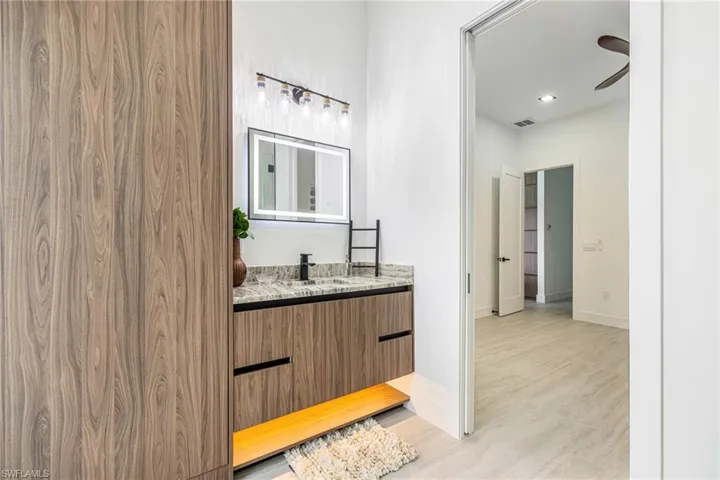 2nd bathroom belongs to the 2nd Guest Bedroom. This one allows this bedroom to be used as a Secondary Primary. Leads out to the pool area and has a Large Custom Built in Linen Cabinet. Pocket Door into the bedroom.