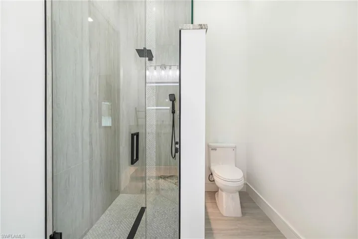 Great walk in shower with rain styled shower head system with wand and linear floor drain. Custom Niche, Bench and LED Lighting.
