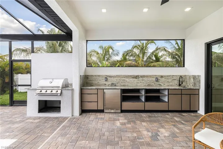 Ok, A custom built in Grill area outside the lanai so the smoke doesn't build up inside the lanai. The weather proof cabinets have so much storage and the Beverage fridge keeps me and my guests from tramping though the house to grab a cold one! There's a sink out here too? Wow this Granite backsplash makes it easy to clean. Ceilign fans and recessed lighting allows us to enjoy this added living space in the evenings!