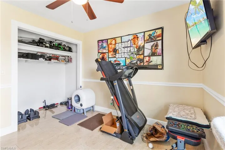 Exercise area featuring baseboards and a ceiling fan