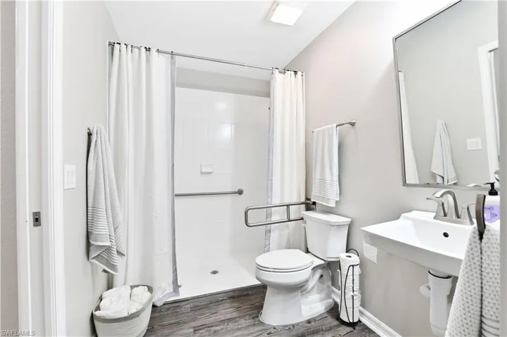 Bathroom featuring a shower stall and wood finished floors