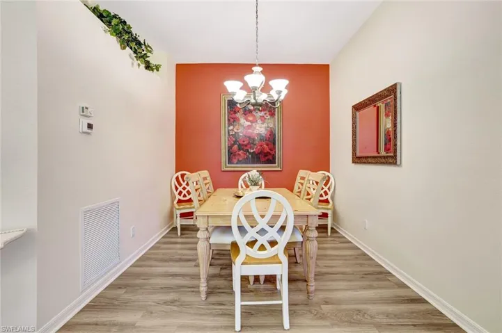 Dining area featuring light wood finished floors and a chandelier