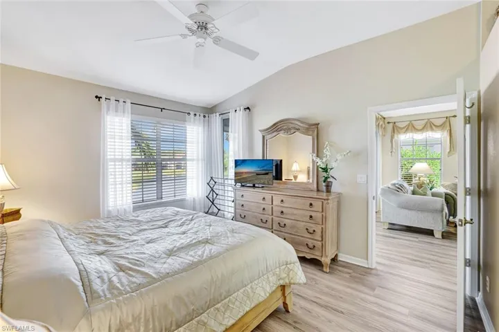 Bedroom featuring lofted ceiling, light wood finished floors, and a ceiling fan