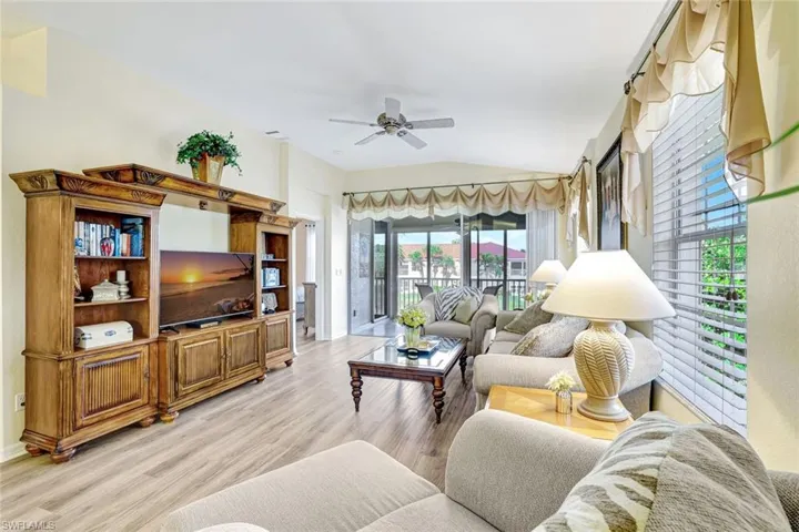 Living area with lofted ceiling, light wood-style floors, and a ceiling fan
