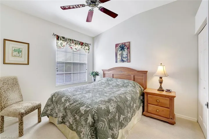 Carpeted bedroom with lofted ceiling, a closet, and a ceiling fan