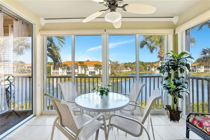 Sunroom featuring a water view, tile patterned floors, and plenty of natural light