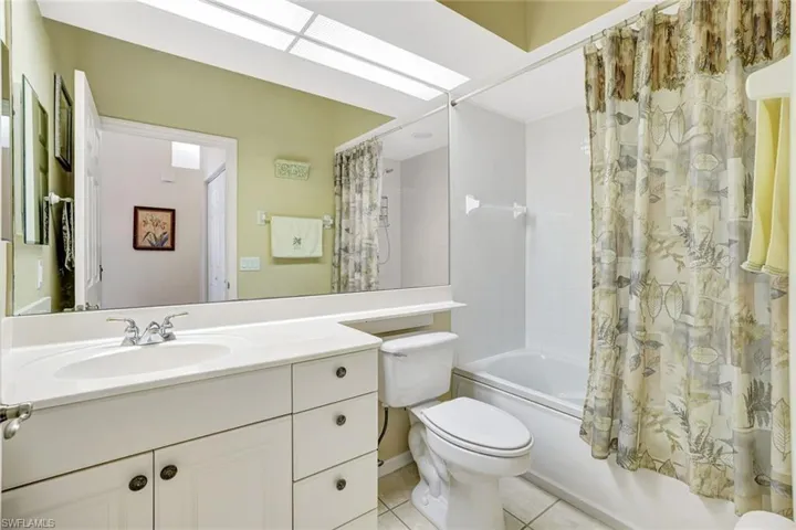 Full bathroom featuring shower / tub combo, vanity, and light tile patterned floors