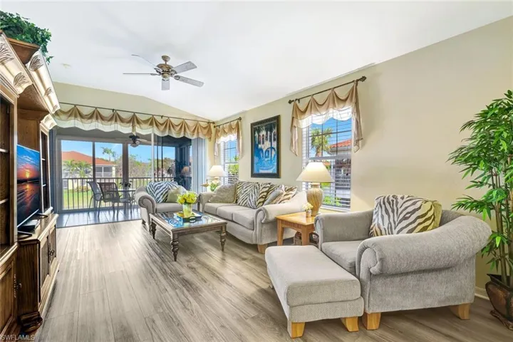 Living area featuring vaulted ceiling, wood finished floors, and a ceiling fan