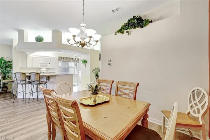 Dining room featuring light wood-style flooring and a chandelier