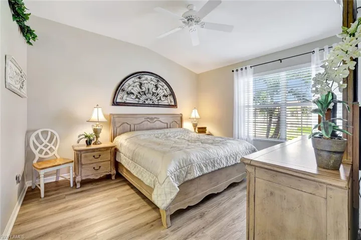 Bedroom with lofted ceiling, light wood-style floors, and a ceiling fan