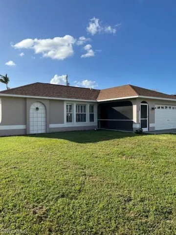Ranch-style home with a front yard and a garage