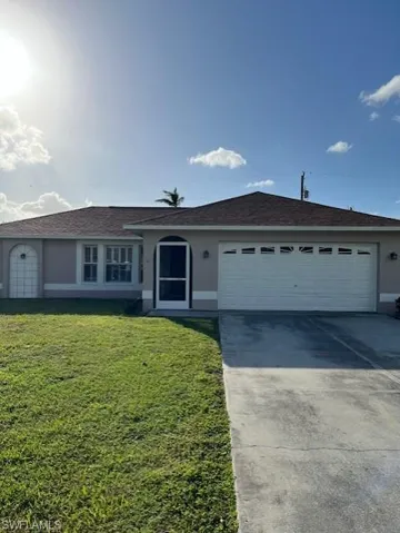 Single story home featuring a front yard and a garage