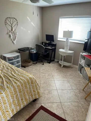 Tiled bedroom featuring ceiling fan