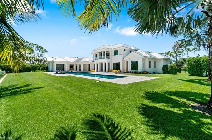 Rear view of property featuring a lawn and a patio area