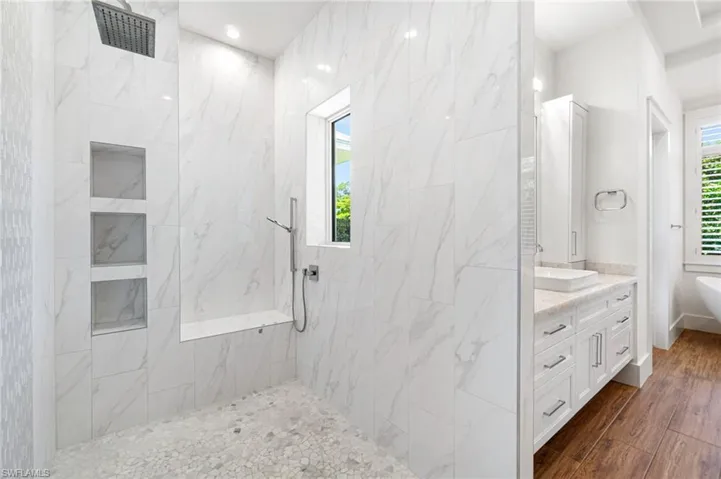 Bathroom featuring shower with separate bathtub, wood-type flooring, and vanity