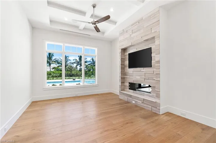 Unfurnished living room with tile walls, light hardwood / wood-style floors, and ceiling fan