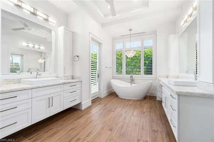 Bathroom with hardwood / wood-style flooring, a wealth of natural light, and a bathtub