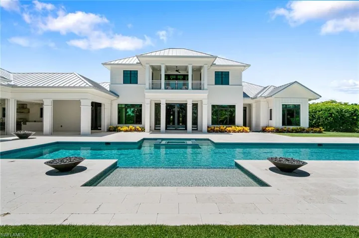 Back of property featuring a balcony and a patio area