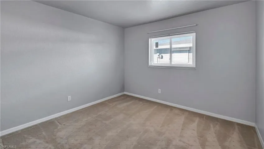 Empty room with light carpet and baseboards
