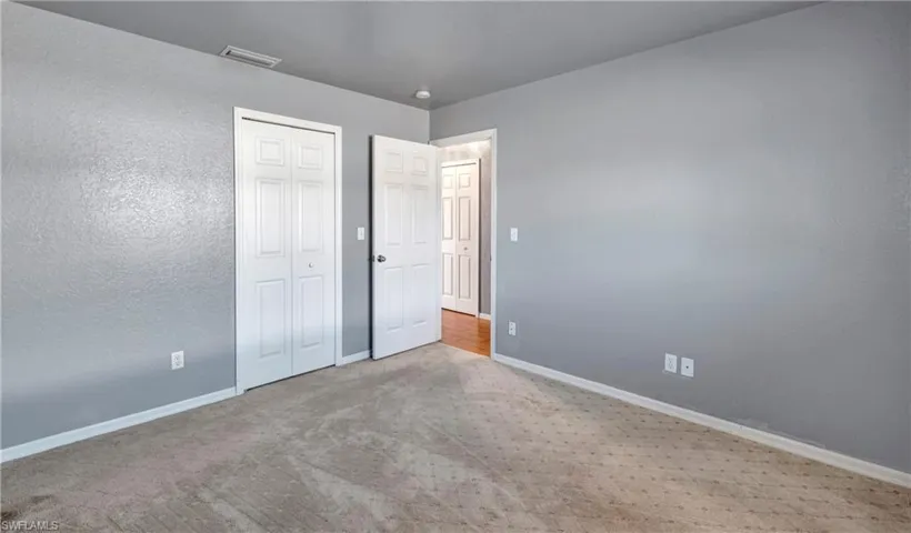 Unfurnished bedroom featuring carpet floors, a closet, and a textured wall