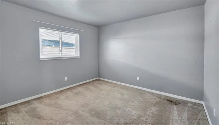 Spare room featuring carpet flooring and a textured wall