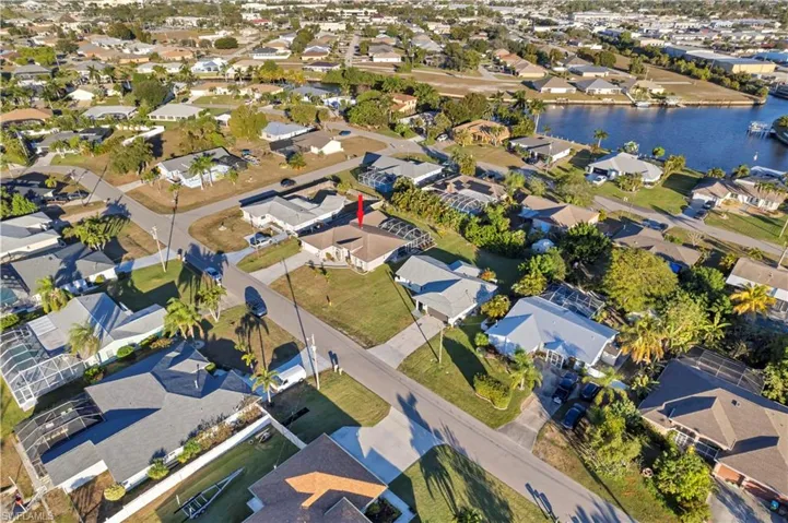 Aerial view of property and surrounding area with nearby suburban area and a large body of water