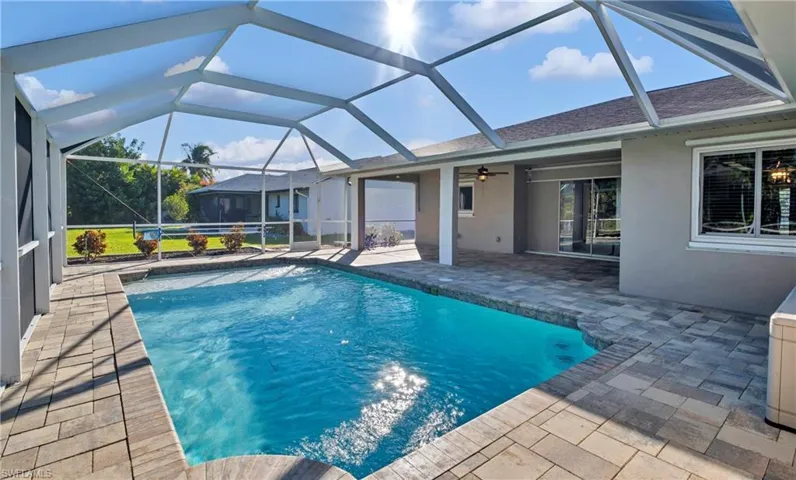 Swimming pool with a patio, a sunroom, and glass enclosure