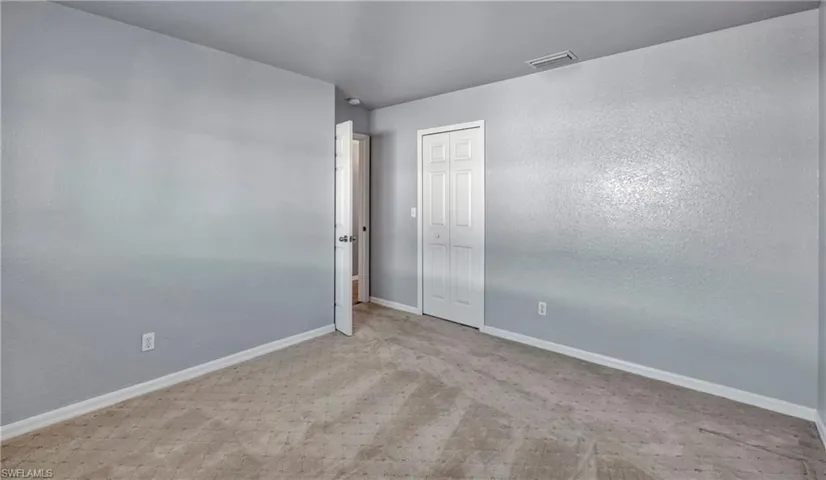 Spare room with light colored carpet and a textured wall